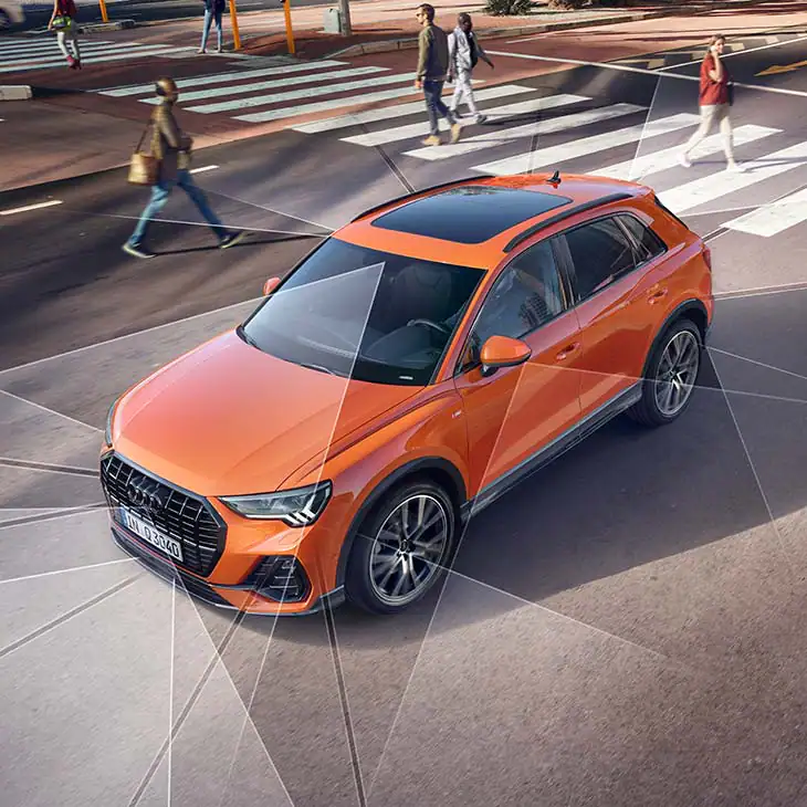 high front angle view of a left hand drive orange audi q3