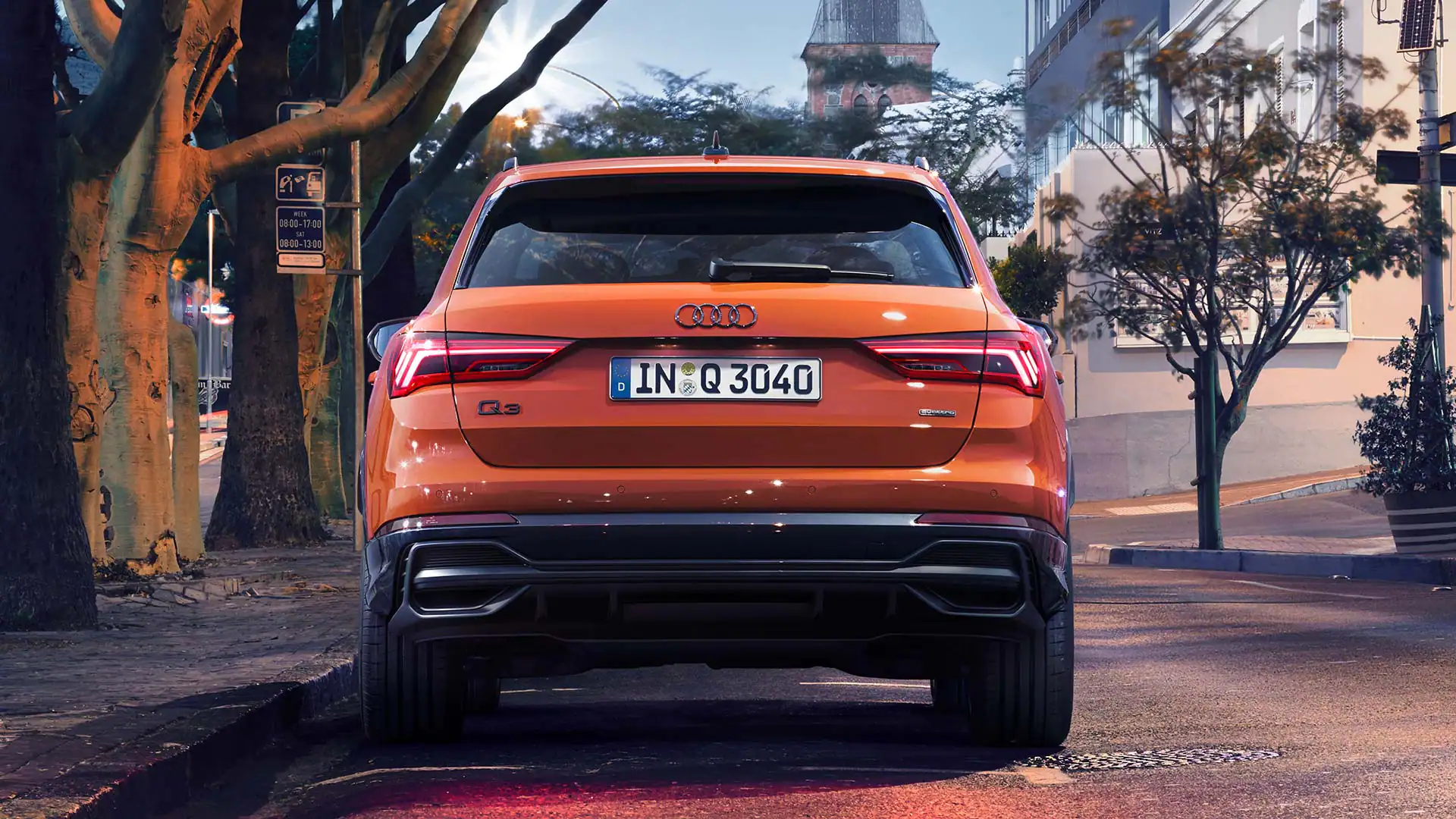rear view of an orange audi q3 parked on a city road