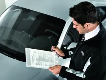 Image of service advisor carrying out vehicle health check on an Audi vehicle