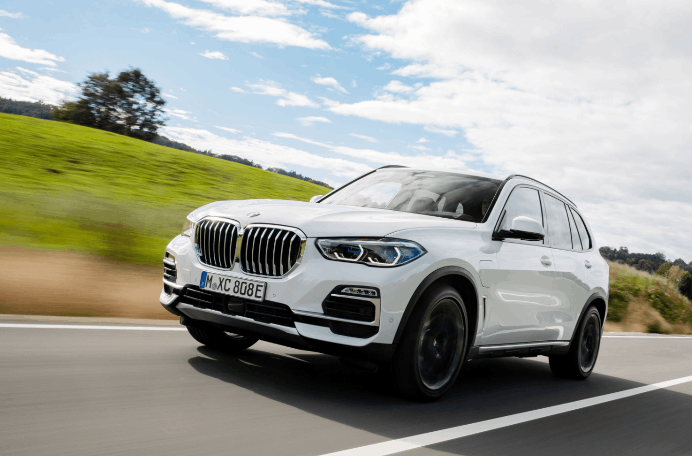 White BMW X5 driving on a road