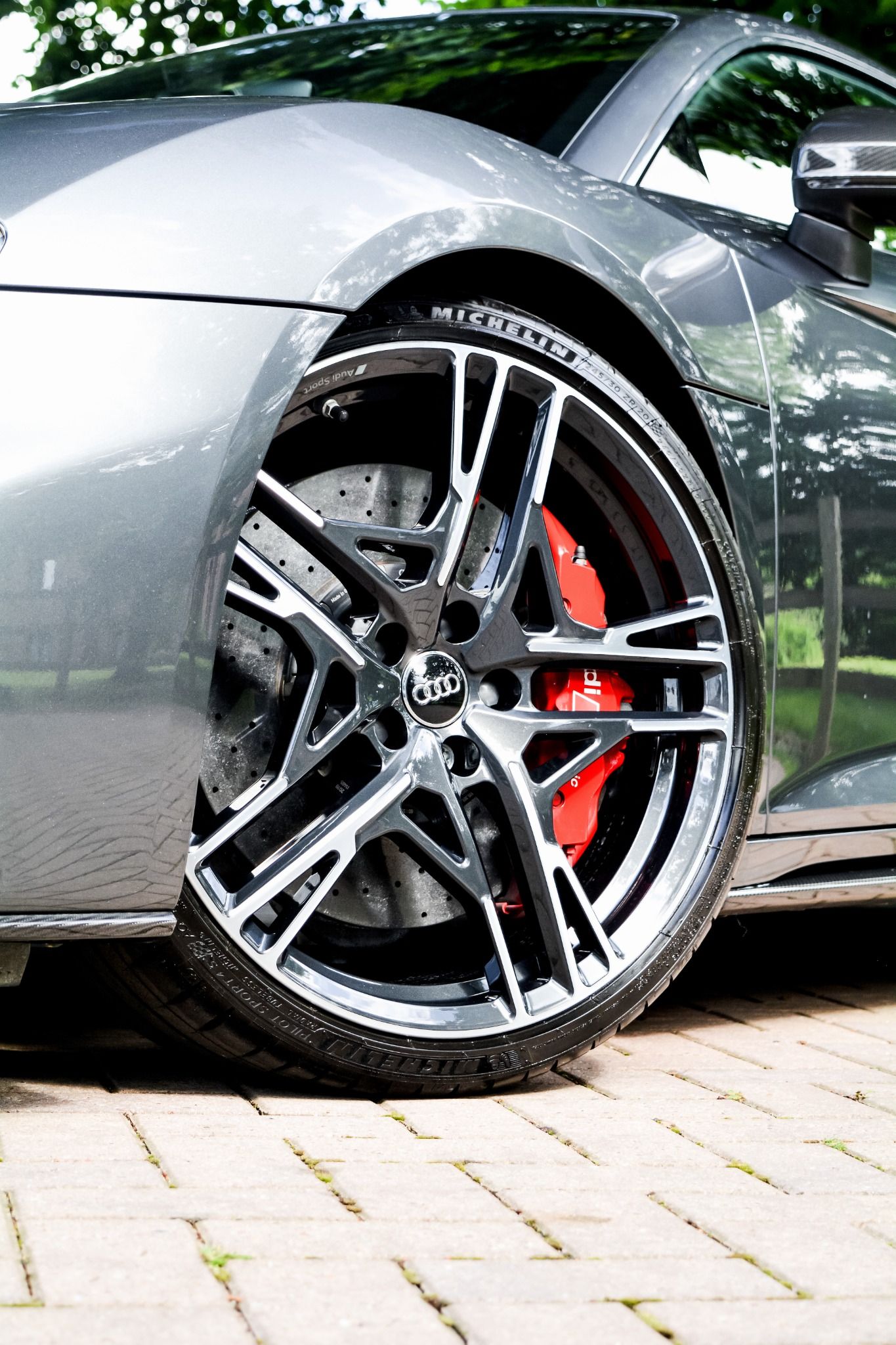 Close up of Audi R8 large grey allow wheel with red brake pads