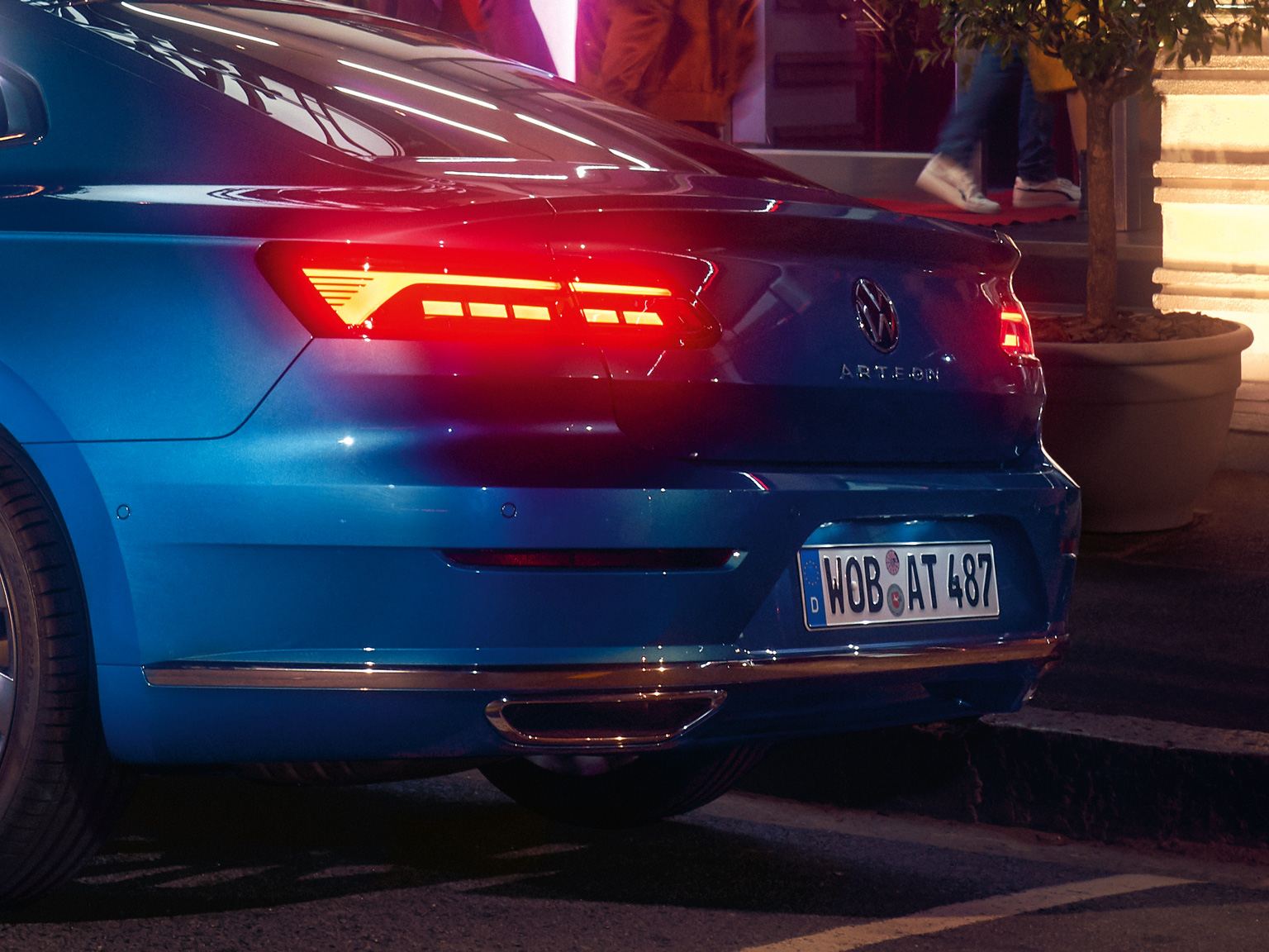close up of a blue rear vw arteon lights illuminated at night