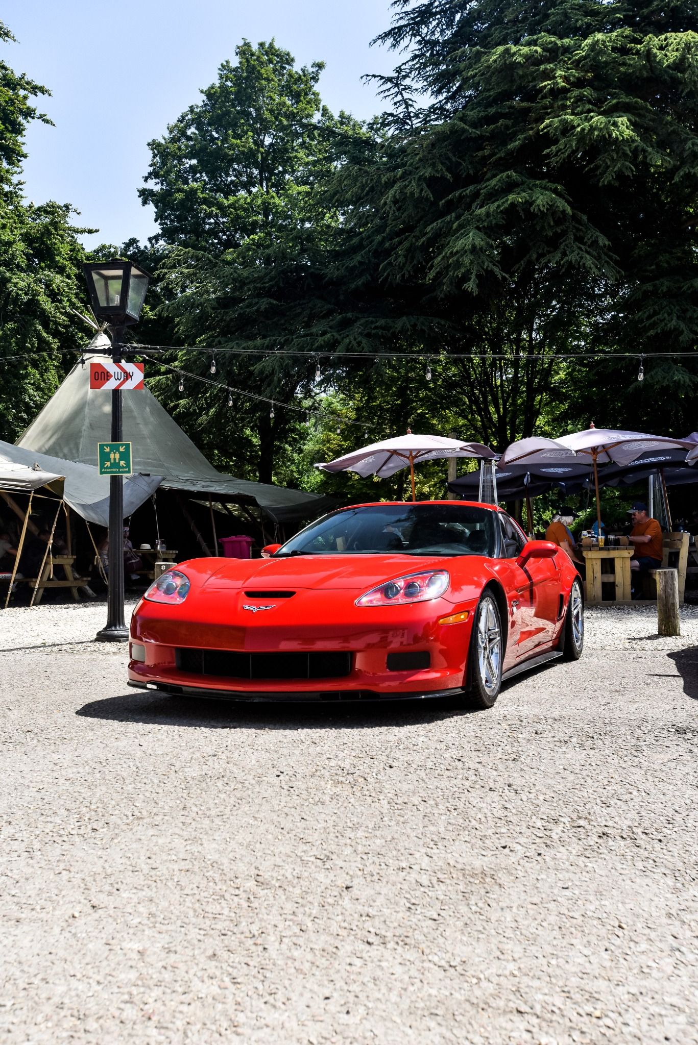 Low angle of a red sports car with picnic benches in the background