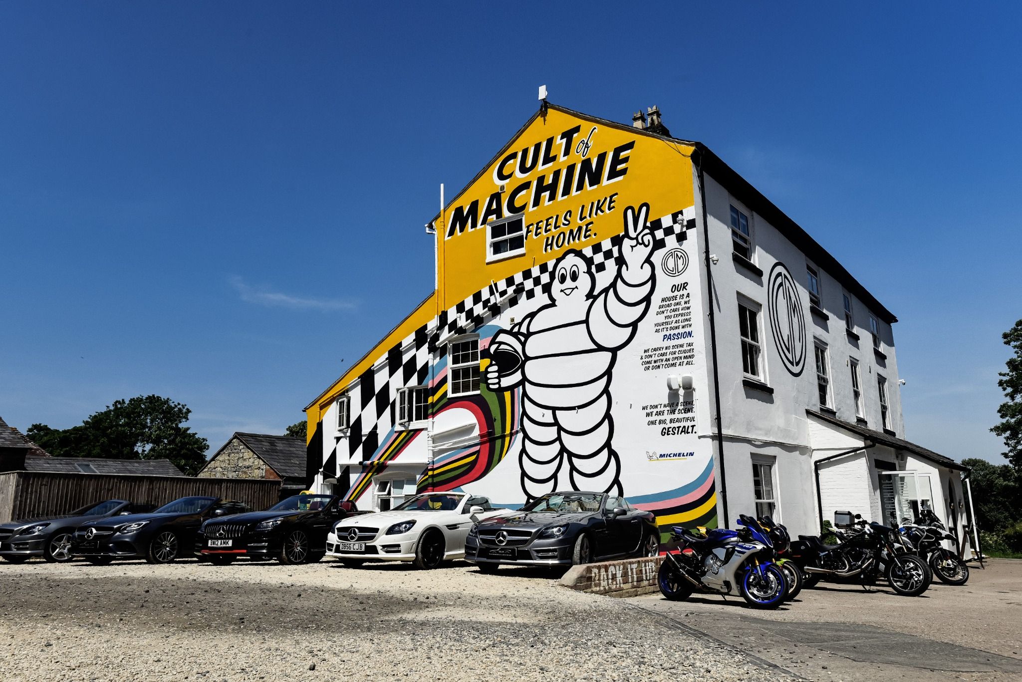 Mercedes in front of a white building with Michelin Tyres painted on the side