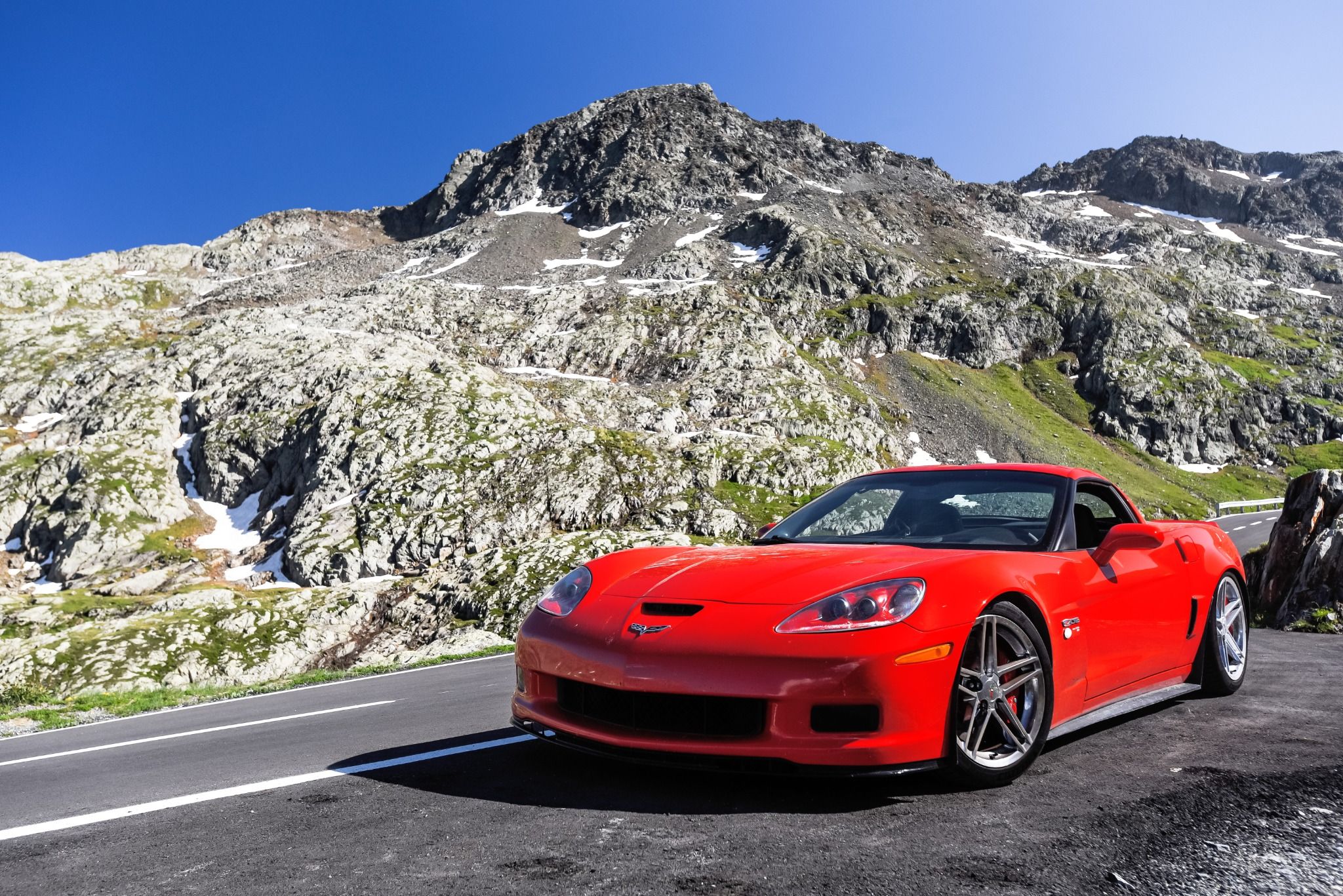 Red sports car in front of mountains