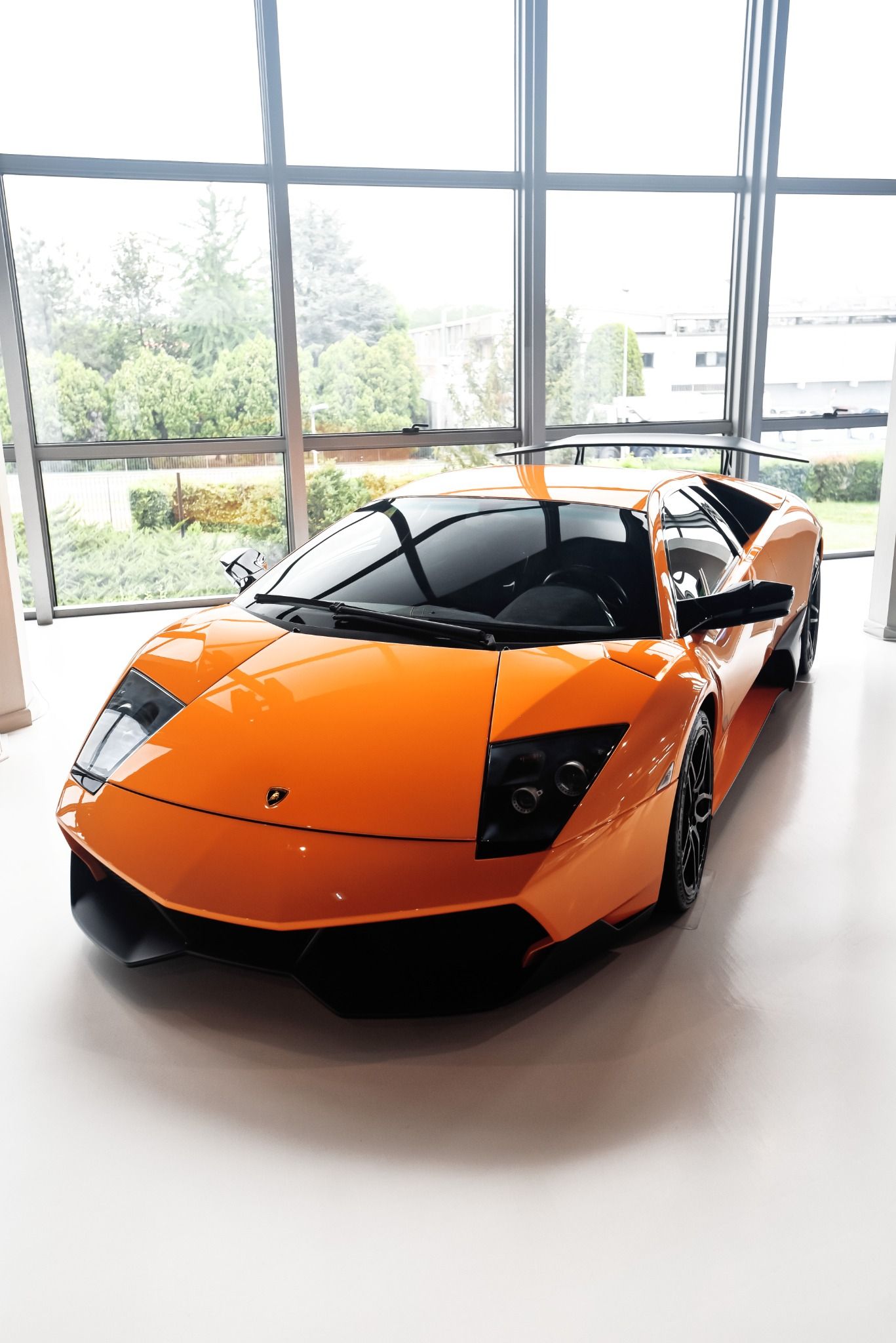 Front view of a yellow lamborghini in front of a big window