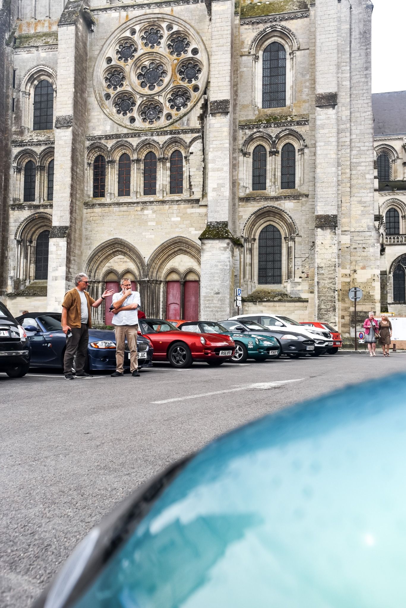 Two men standing in a car park next to a church