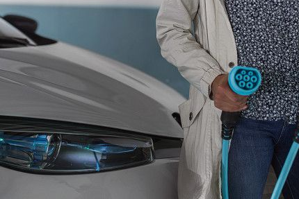 Woman holding an electric vehicle charging cable