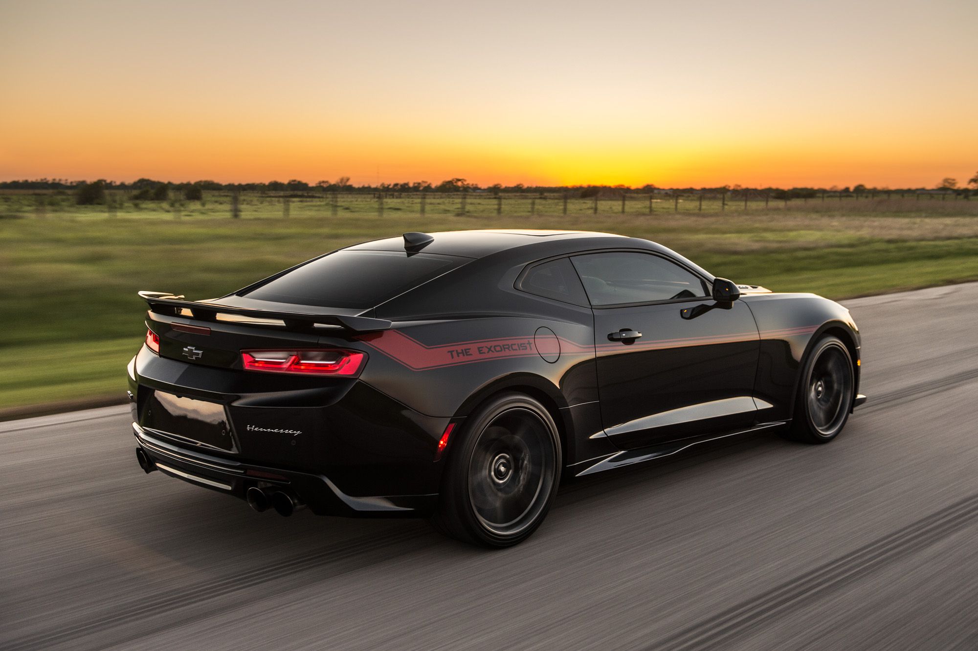 Side and rear view of a Hennessey Exorcist Camaro driving down the road