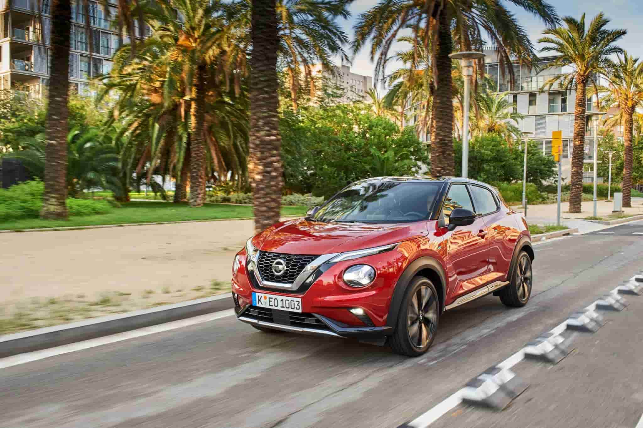 Red Nissan Juke Driving Down the Road