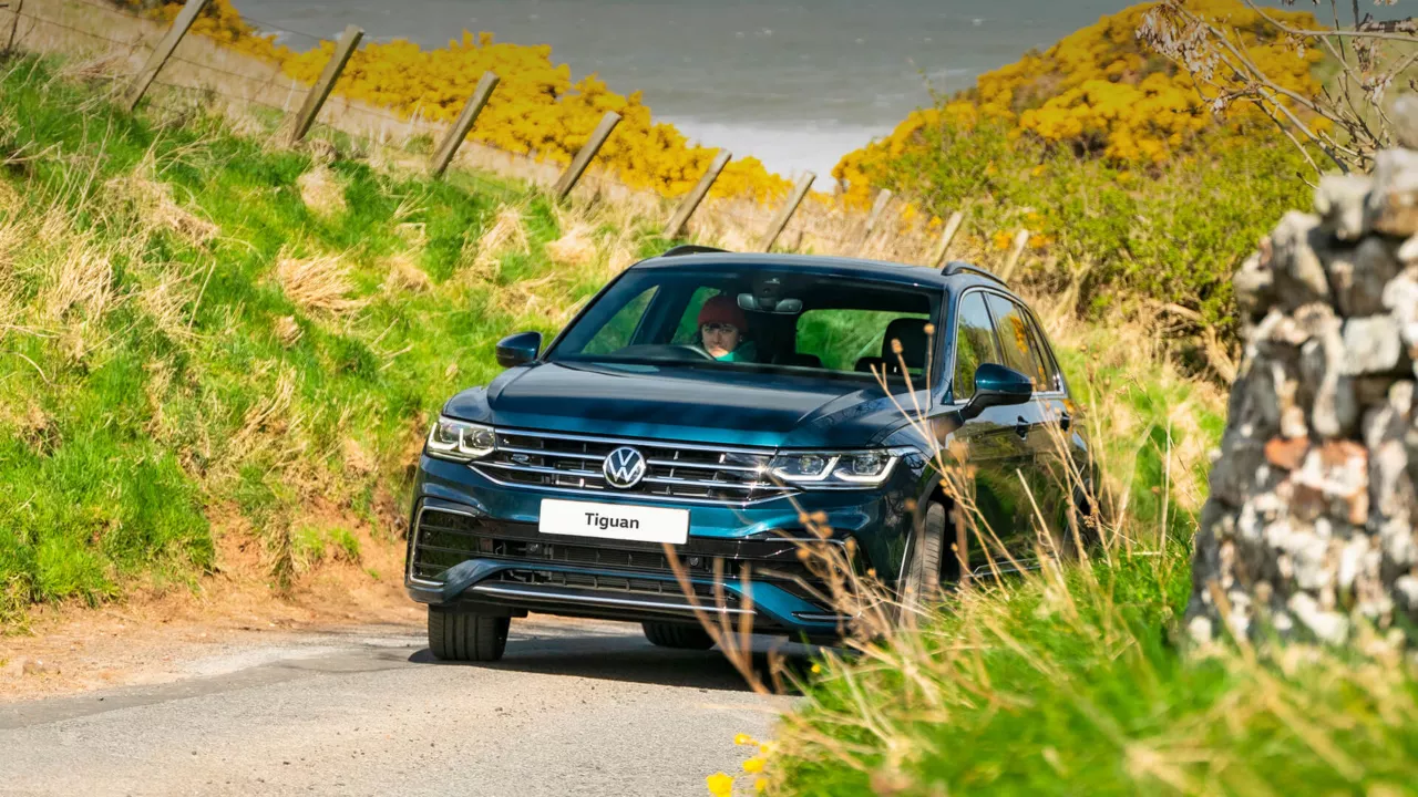 front view of volkswagen tiguan driving up a hill