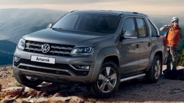 Grey Volkswagen Amarok front parked on top of a hill
