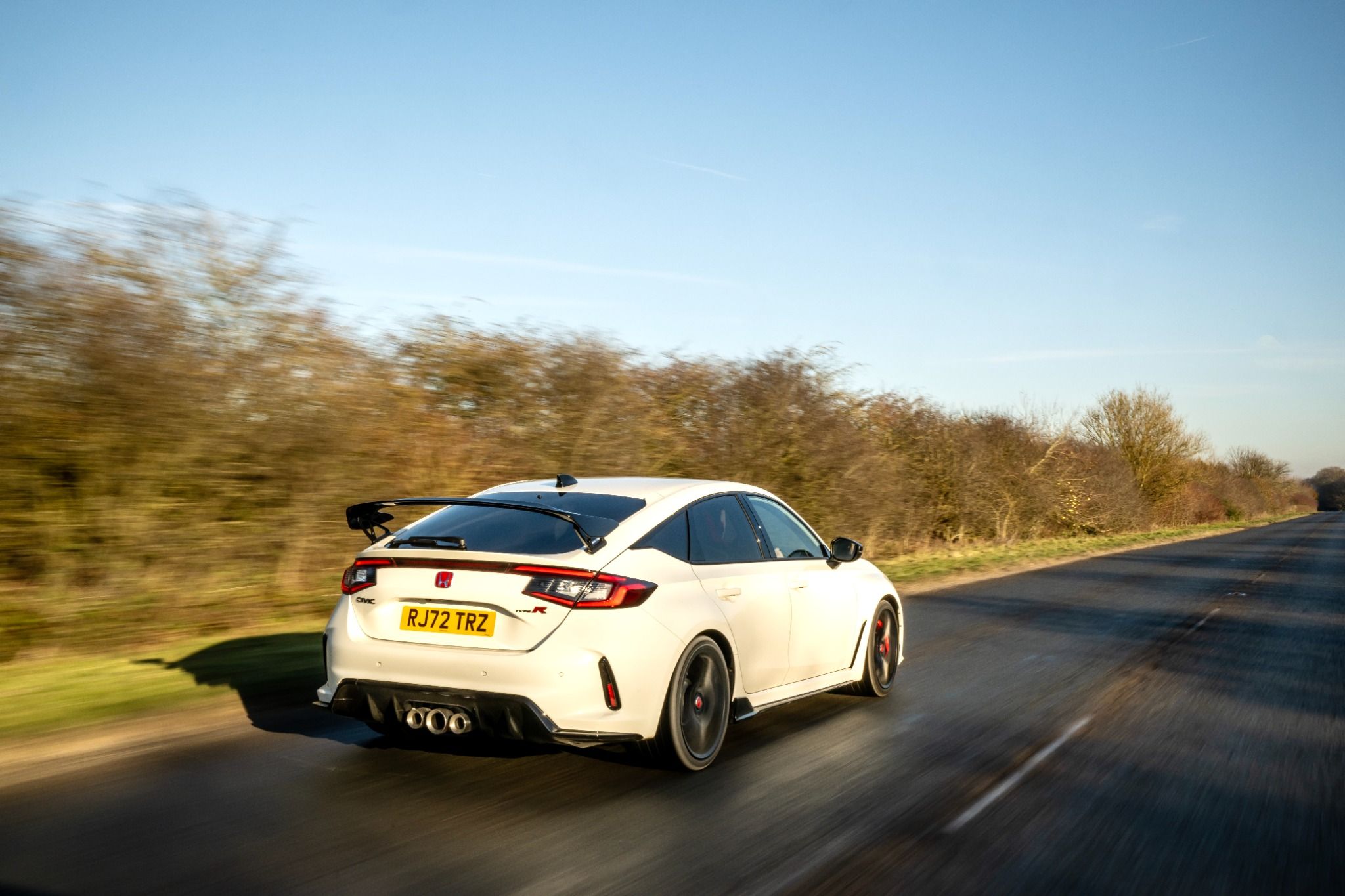 Rear view of New Honda Civic Type R driving on a road
