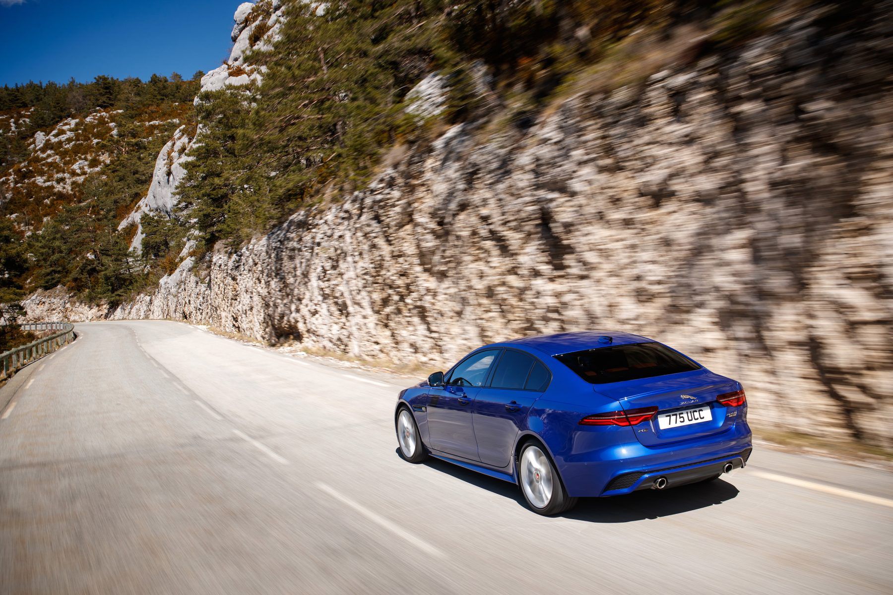 Jaguar XE driving by the side of a rocky mountain