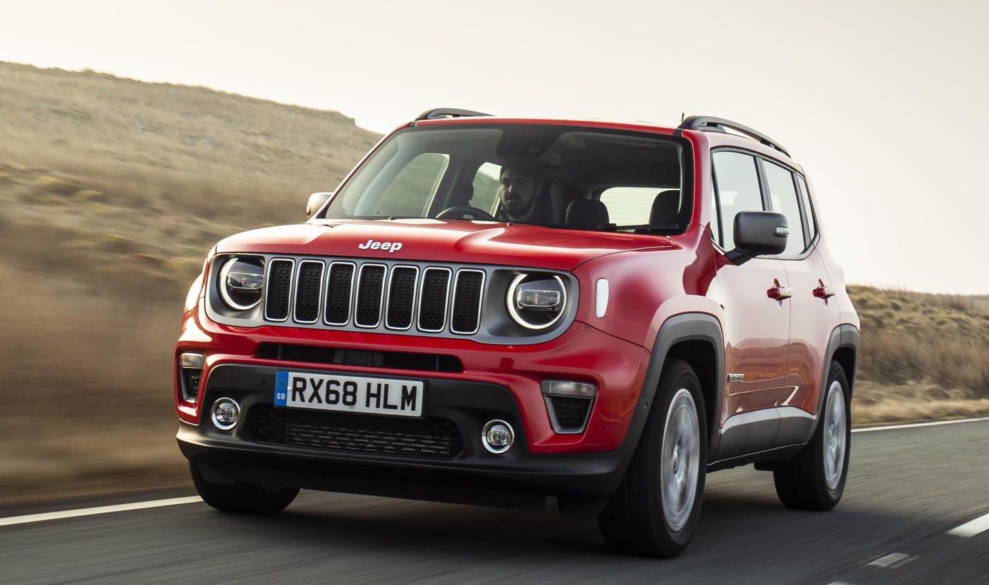 Red jeep renegade driving down the road