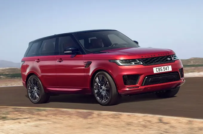 Red Range Rover Sport driving down the road