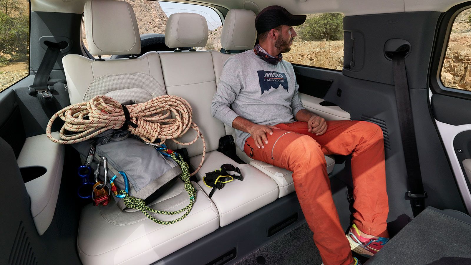 Land Rover defender 130 third row seat with a passenger and his climbing gear