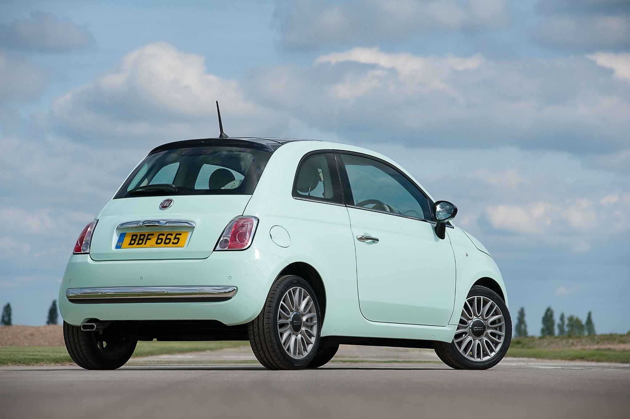 Light mint green fiat 500 parked on a road
