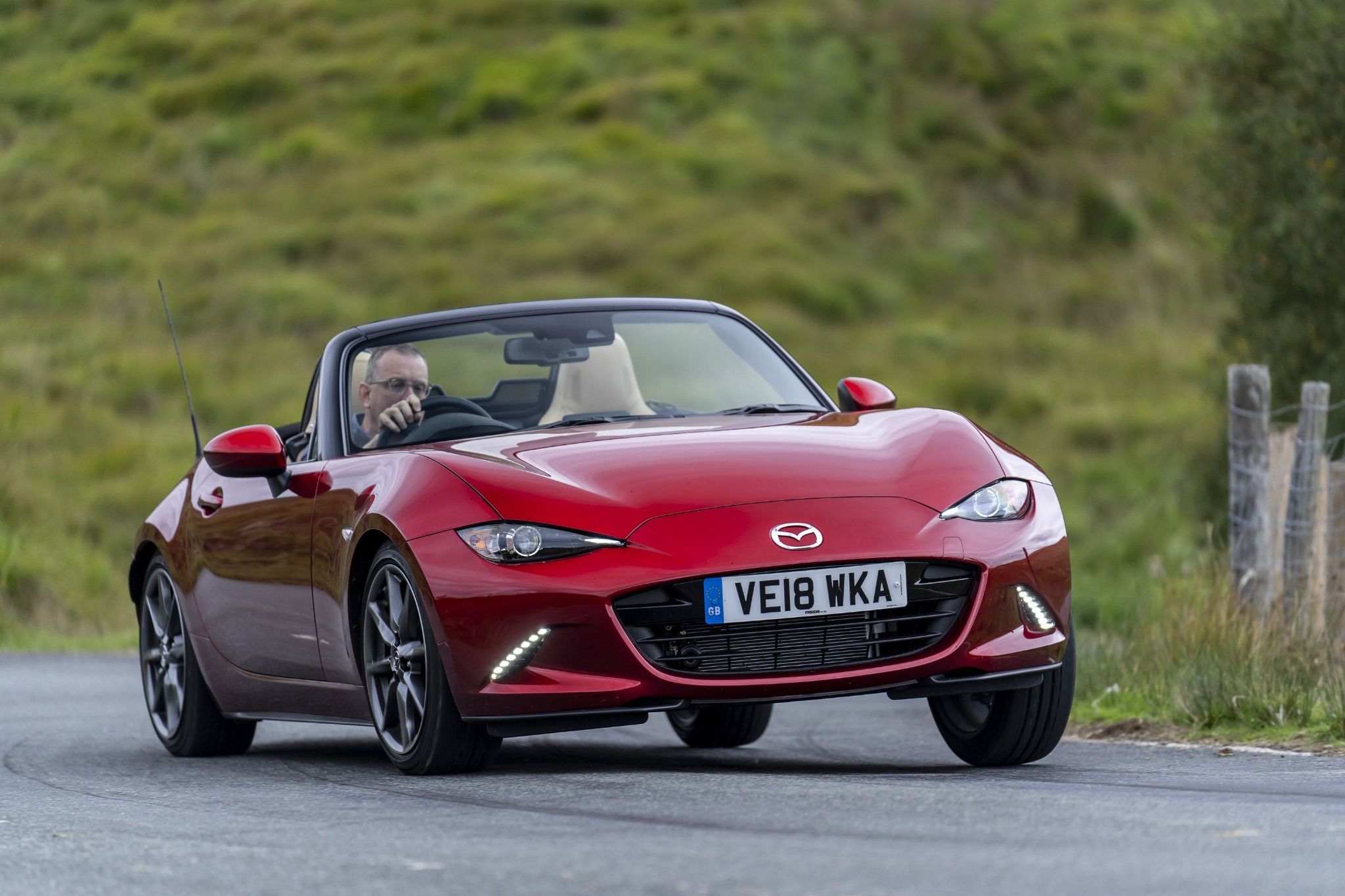 Red Mazda MX-5 driving on a road