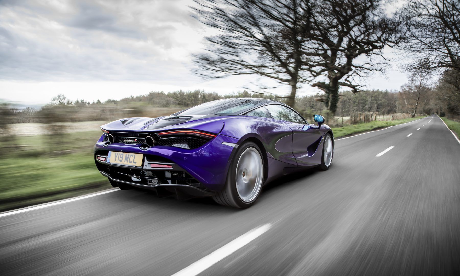 Purple McLaren driving down the road
