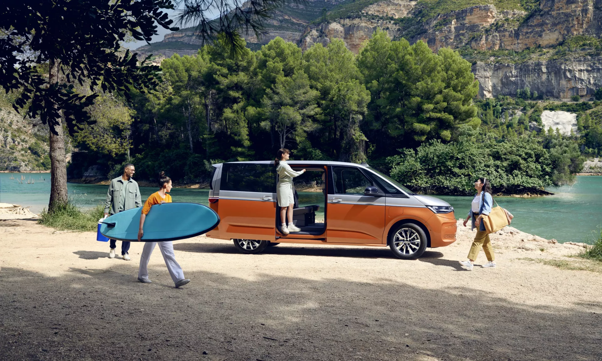 Orange and white VW Multivan at the beach