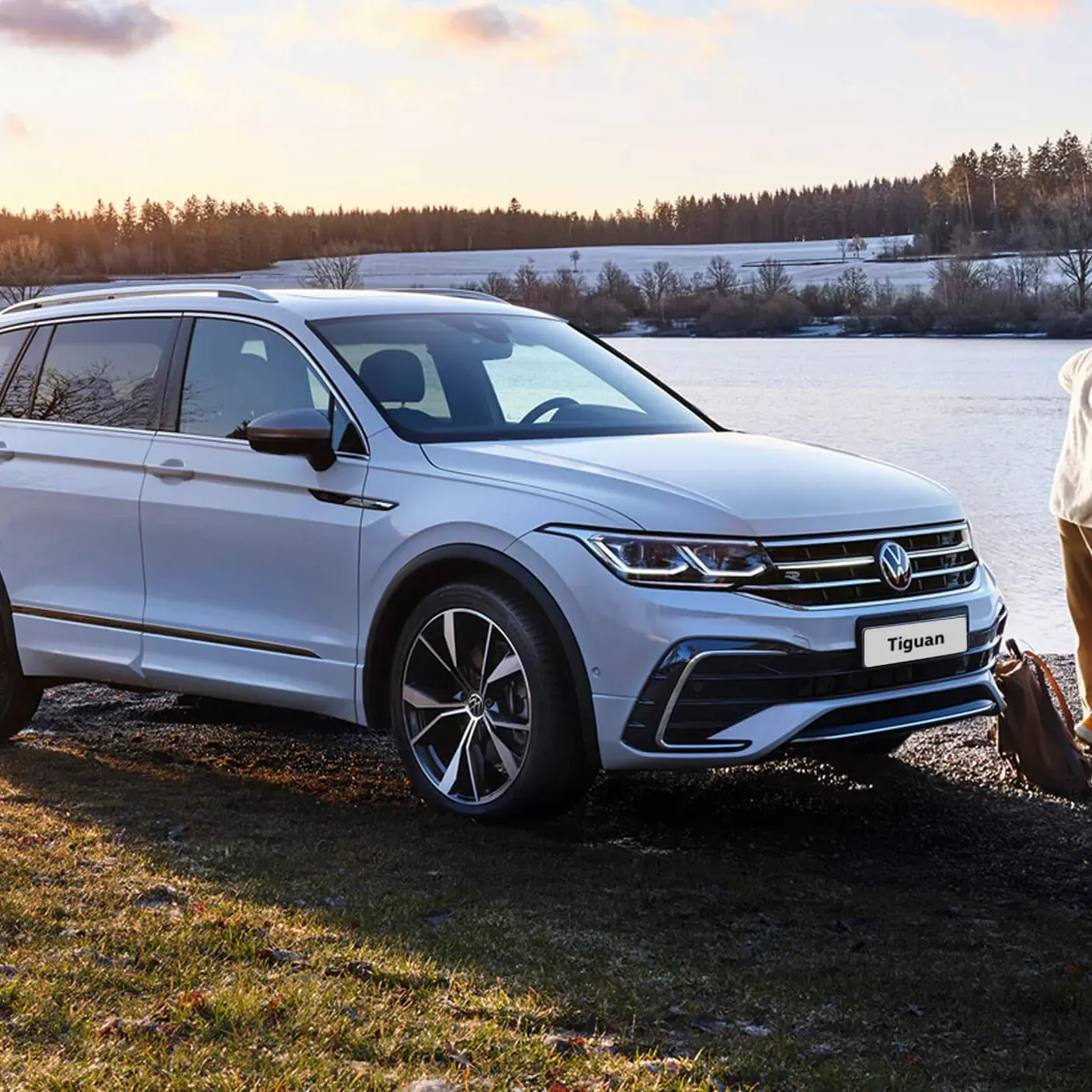 White Volkswagen Tiguan parked in front of a snowy field