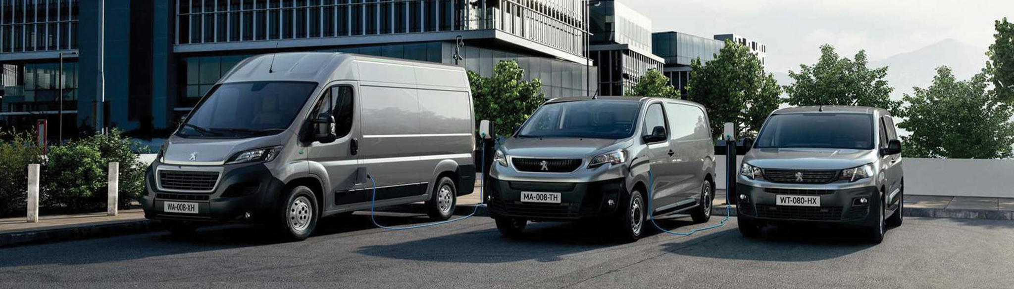 Peugeot e-Boxer, e-Expert and e-Partner Vans lined up on car park city