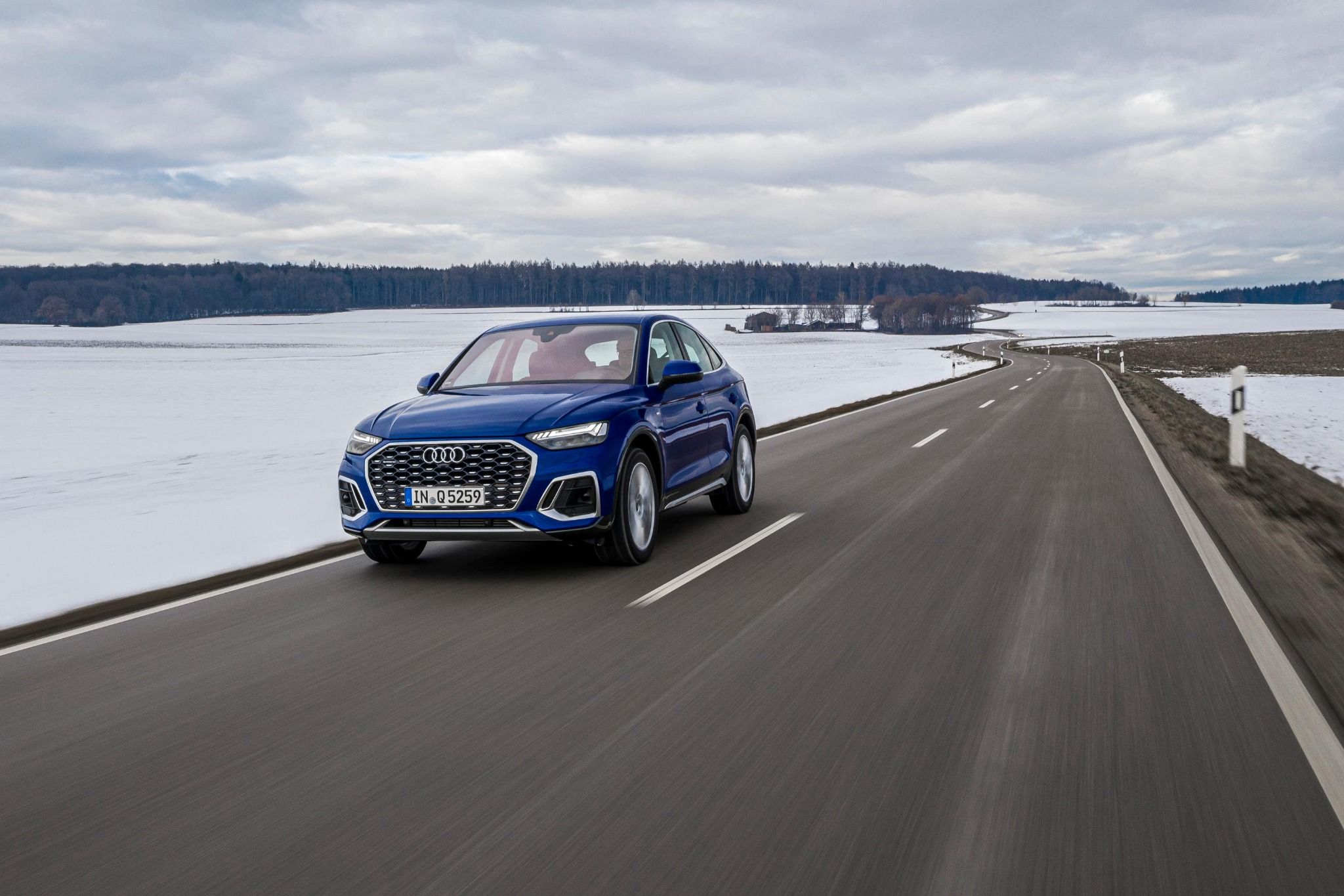 Q5 Sportback driving on a road through the snowy fields