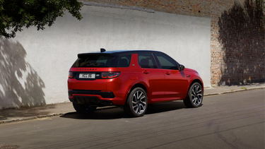 Red Land Rover Discovery Sport parked at side of road