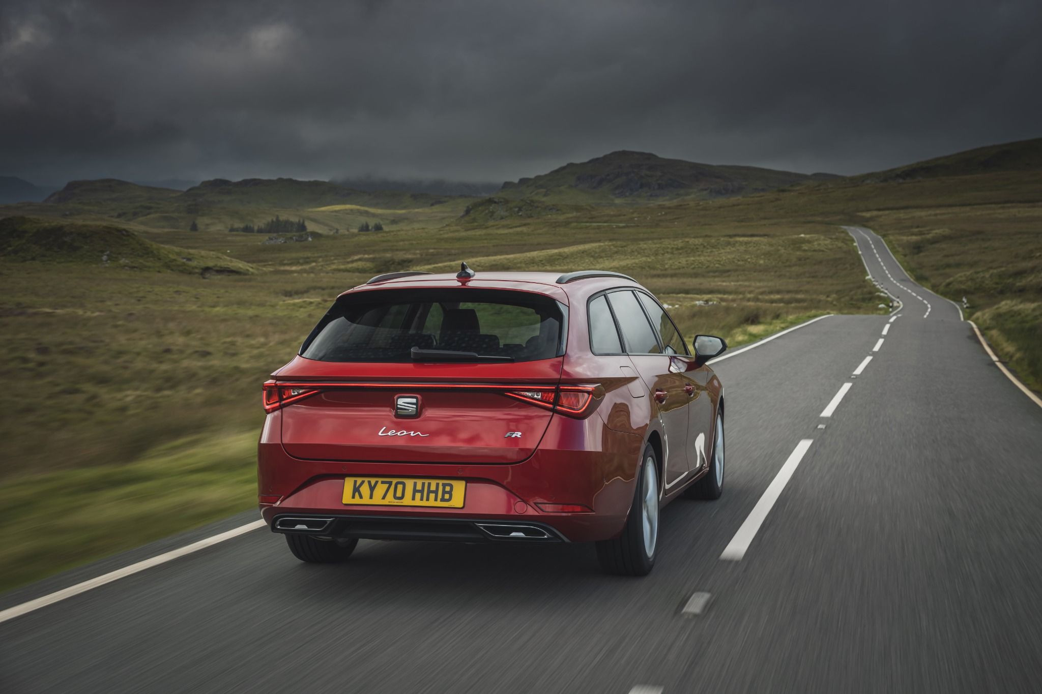 Red SEAT Leon Estate rear driving down the road
