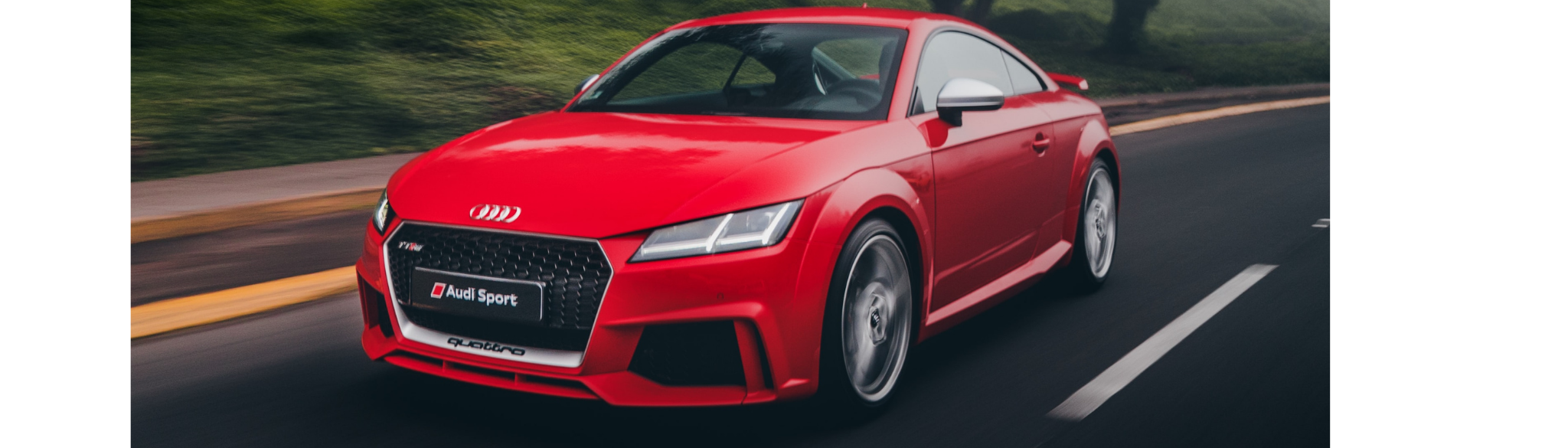 Red Audi TTRS Coupe exterior front driving down the road