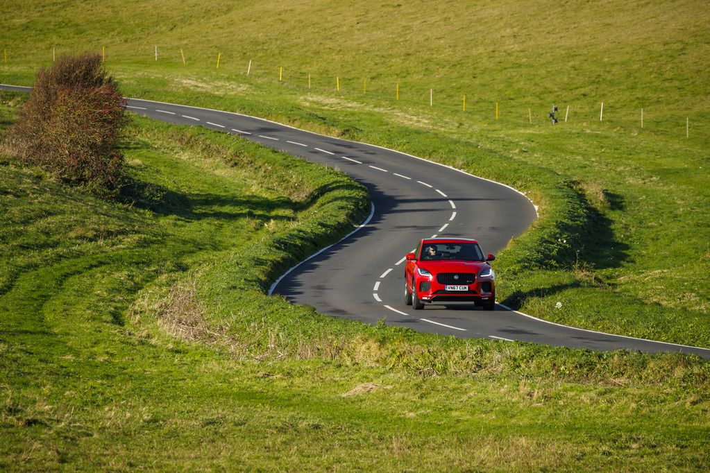 Red jaguar e pace driving on country roads