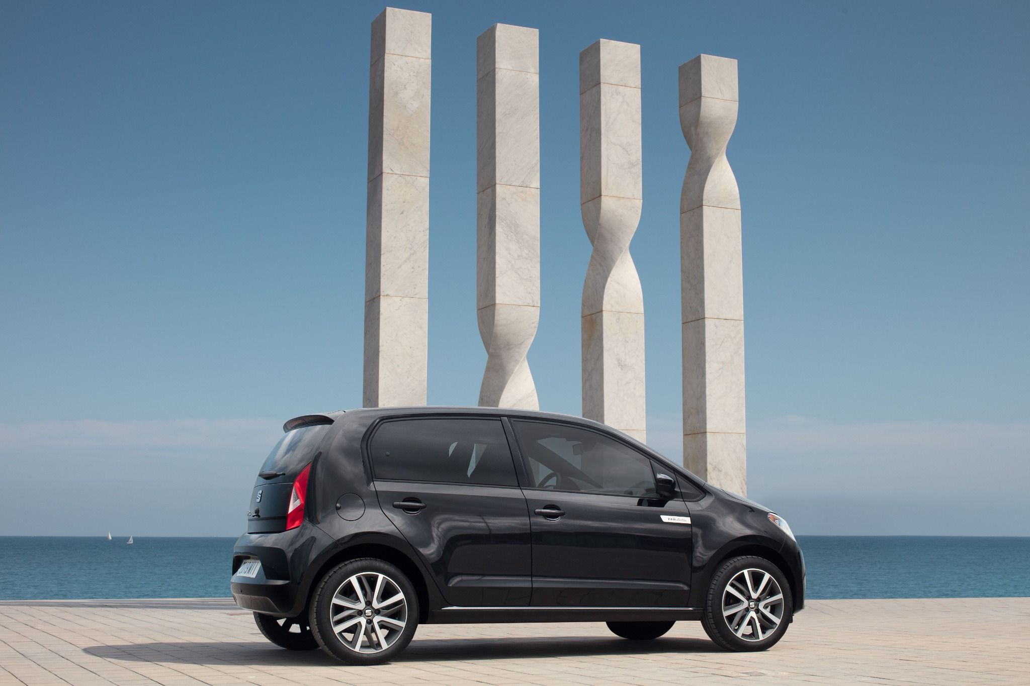 Side view of a seat mii parked on a beach next to pillars