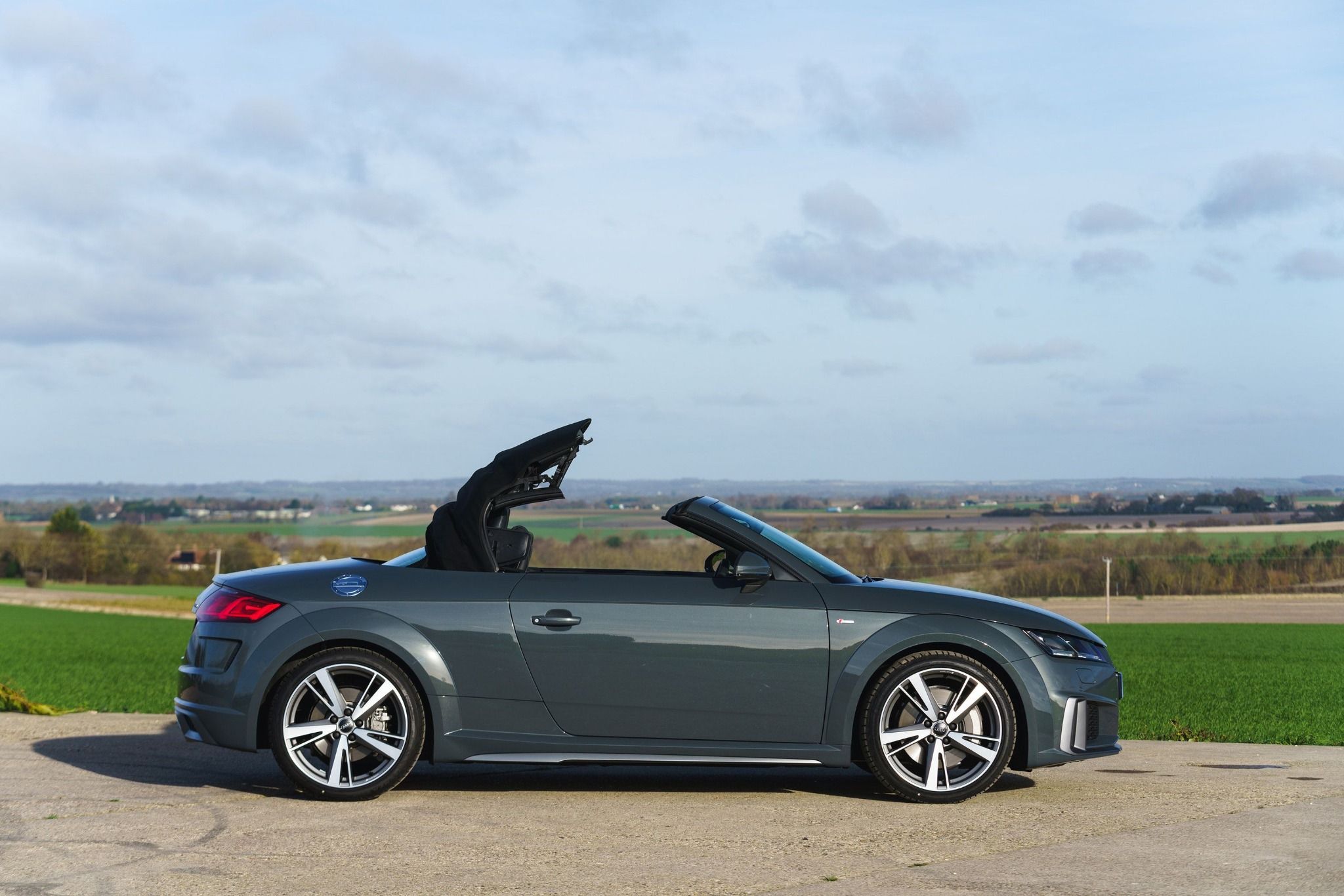 side view of audi tt roadster retracting the roof