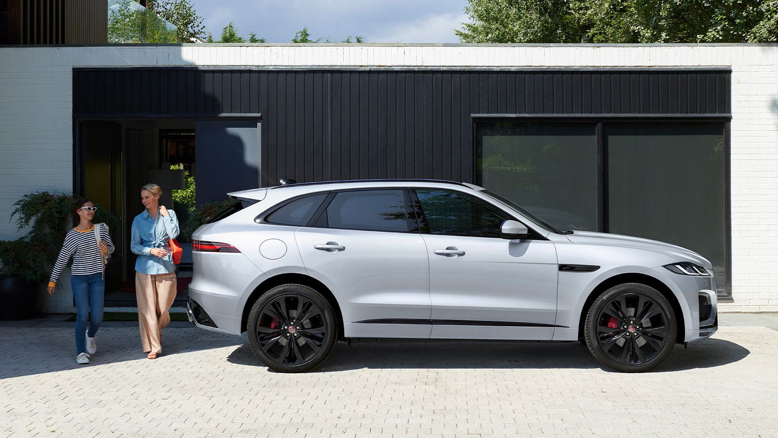 Side view of white Jaguar F Pace on driveway