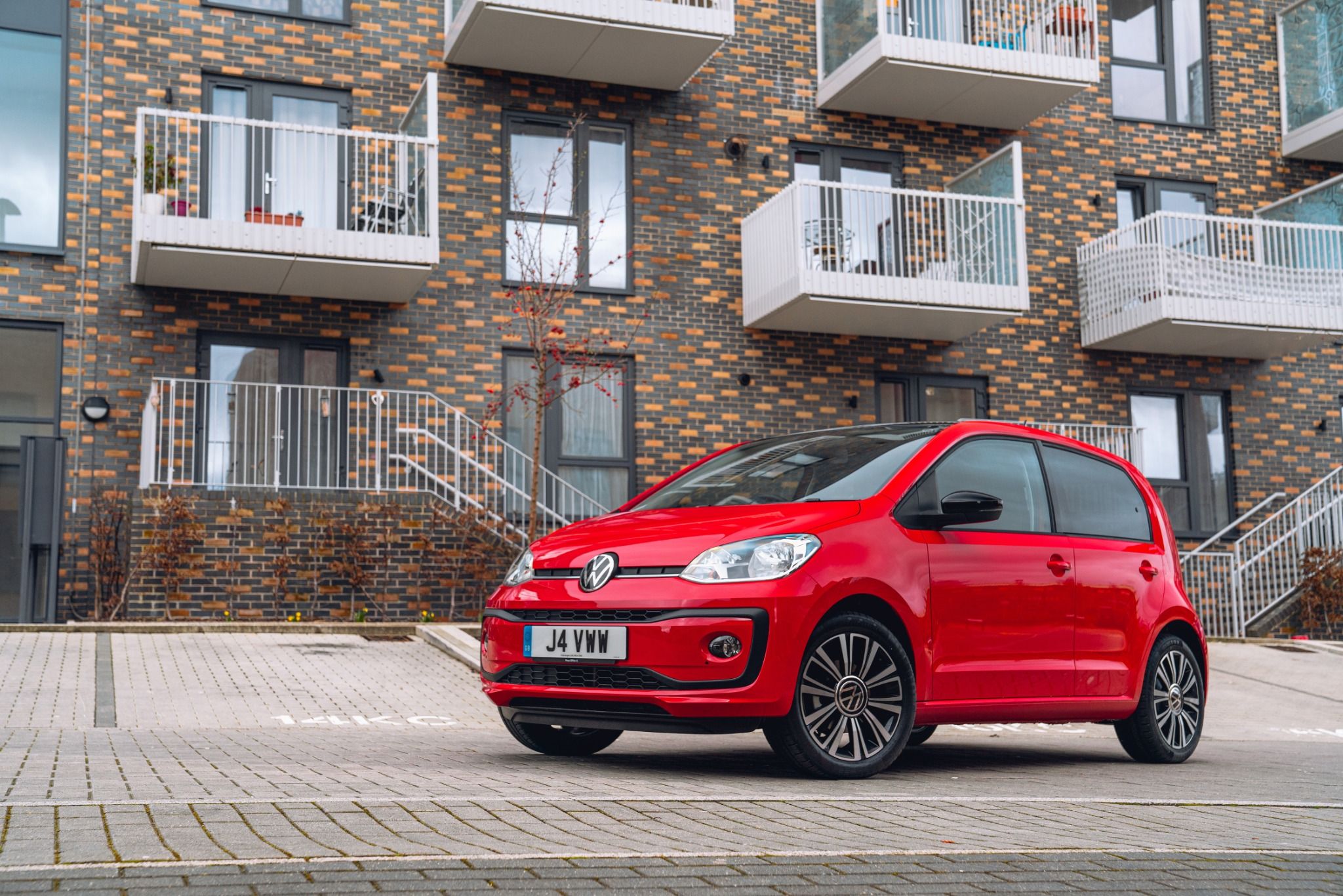Red VW UP parked in front of apartment block