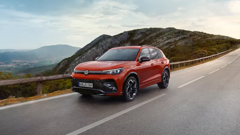 Red Tiguan driving on country lane