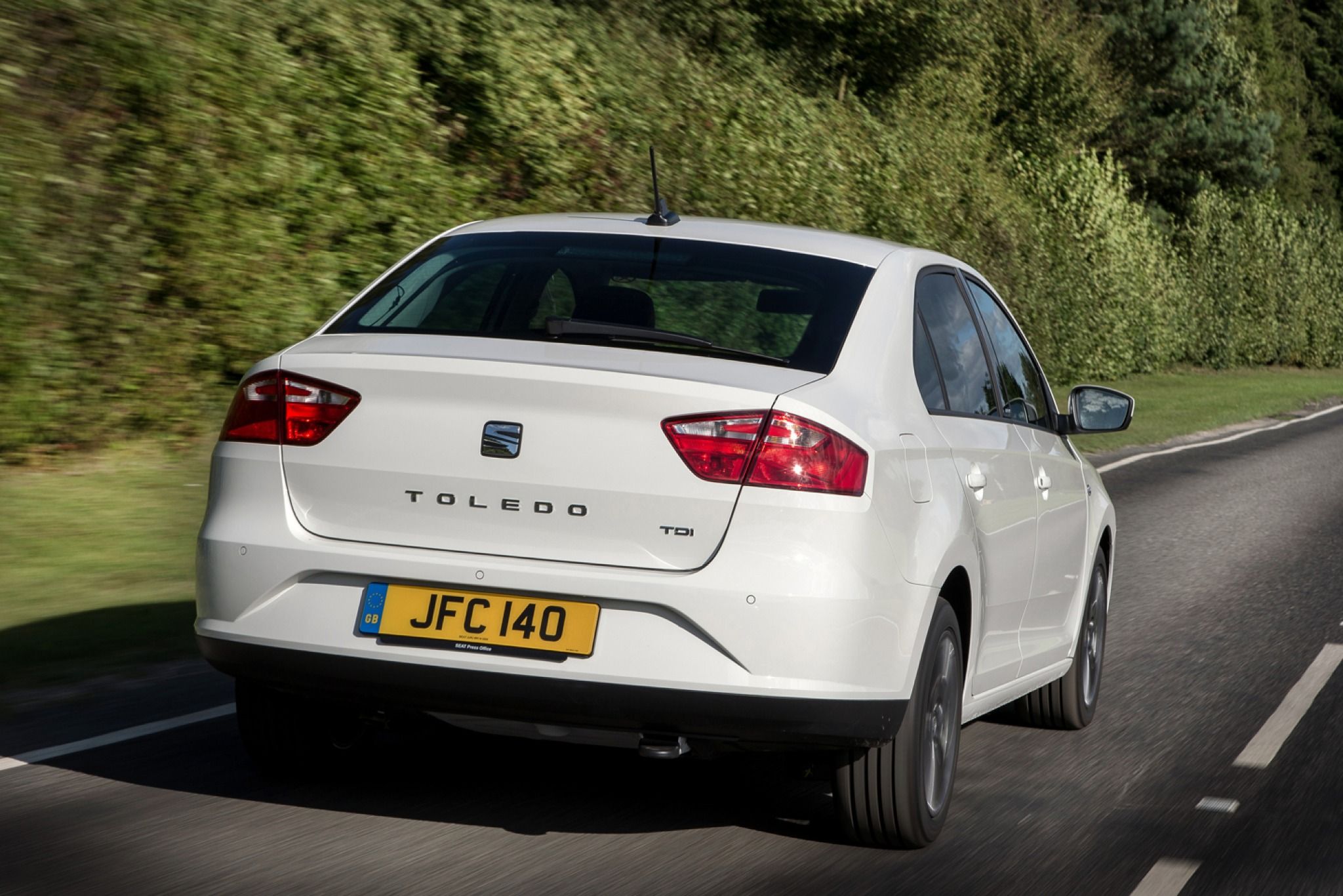 Rear view of a white SEAT Toledo driving down the road