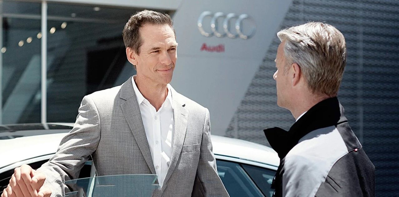 Two men talking outside Audi dealership