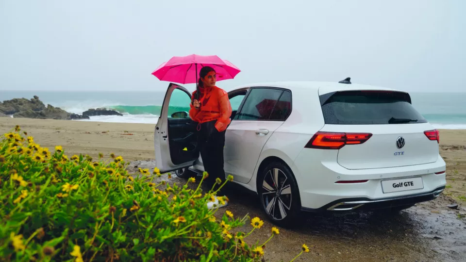 volkswagen golf gte parked on a beach in the rain