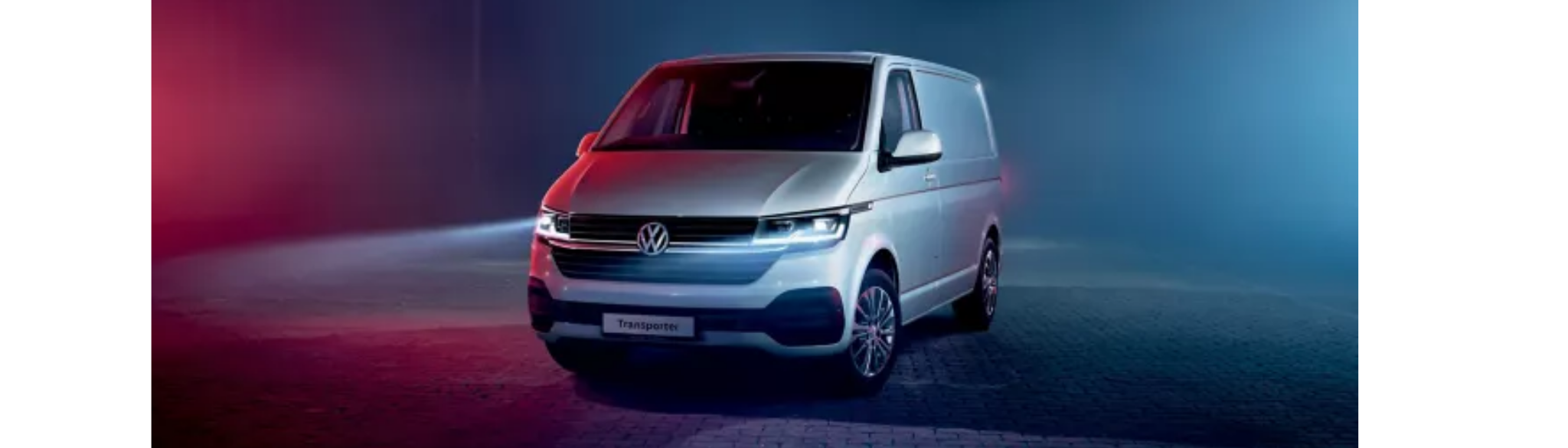 White Volkswagen Transporter parked with lights on