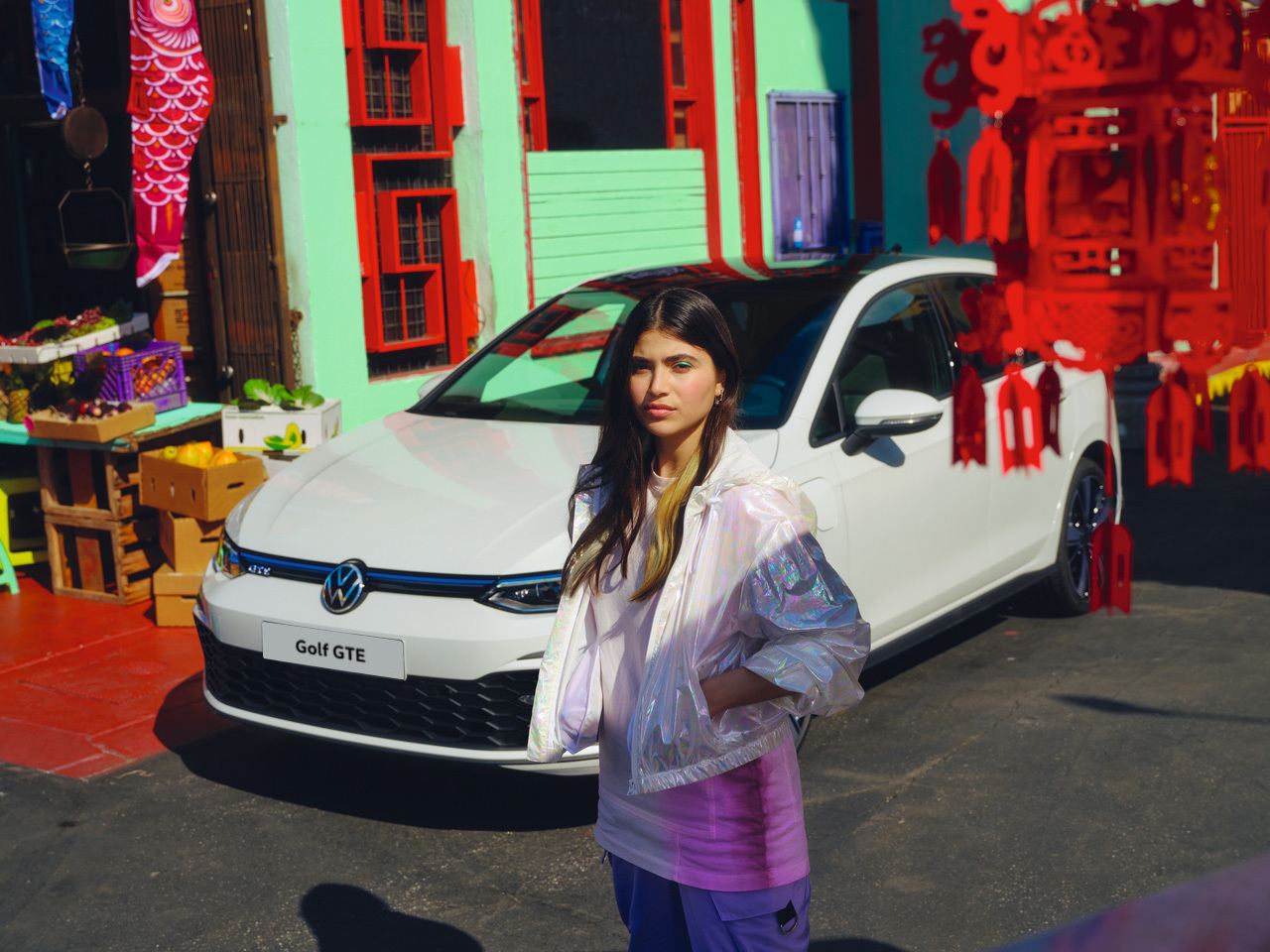 woman stood in front of a White Volkswagen Golf GTD