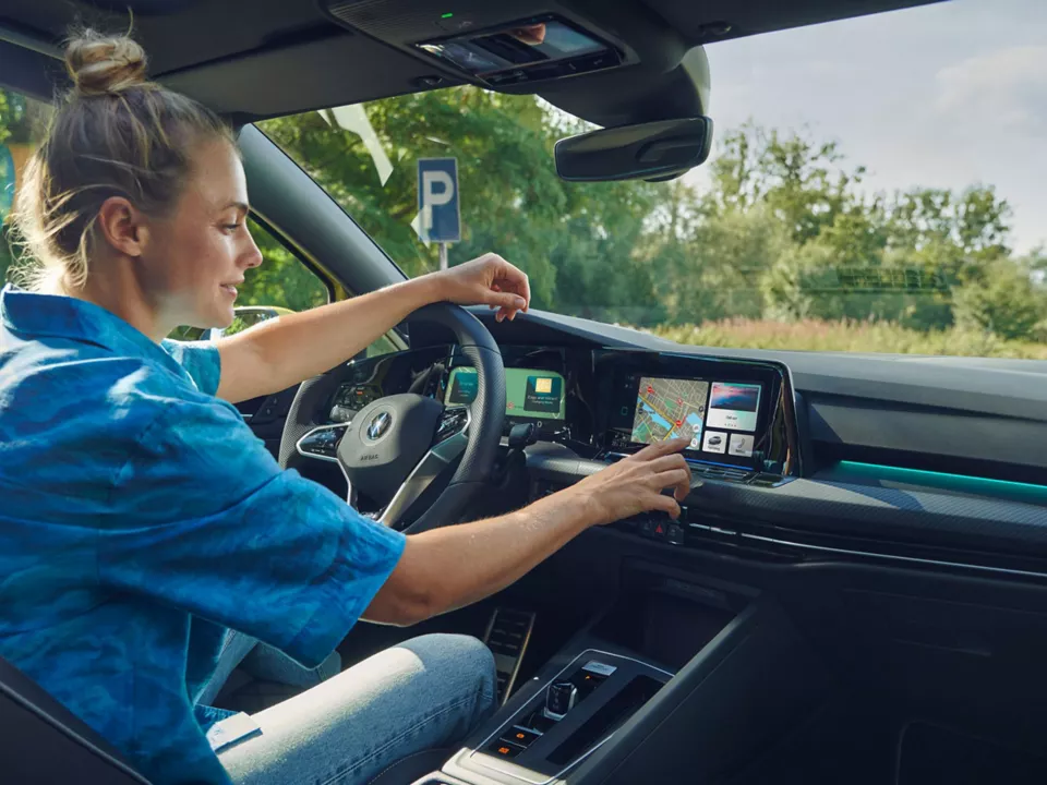 woman using touchscreen within Volkswagen Golf Estate