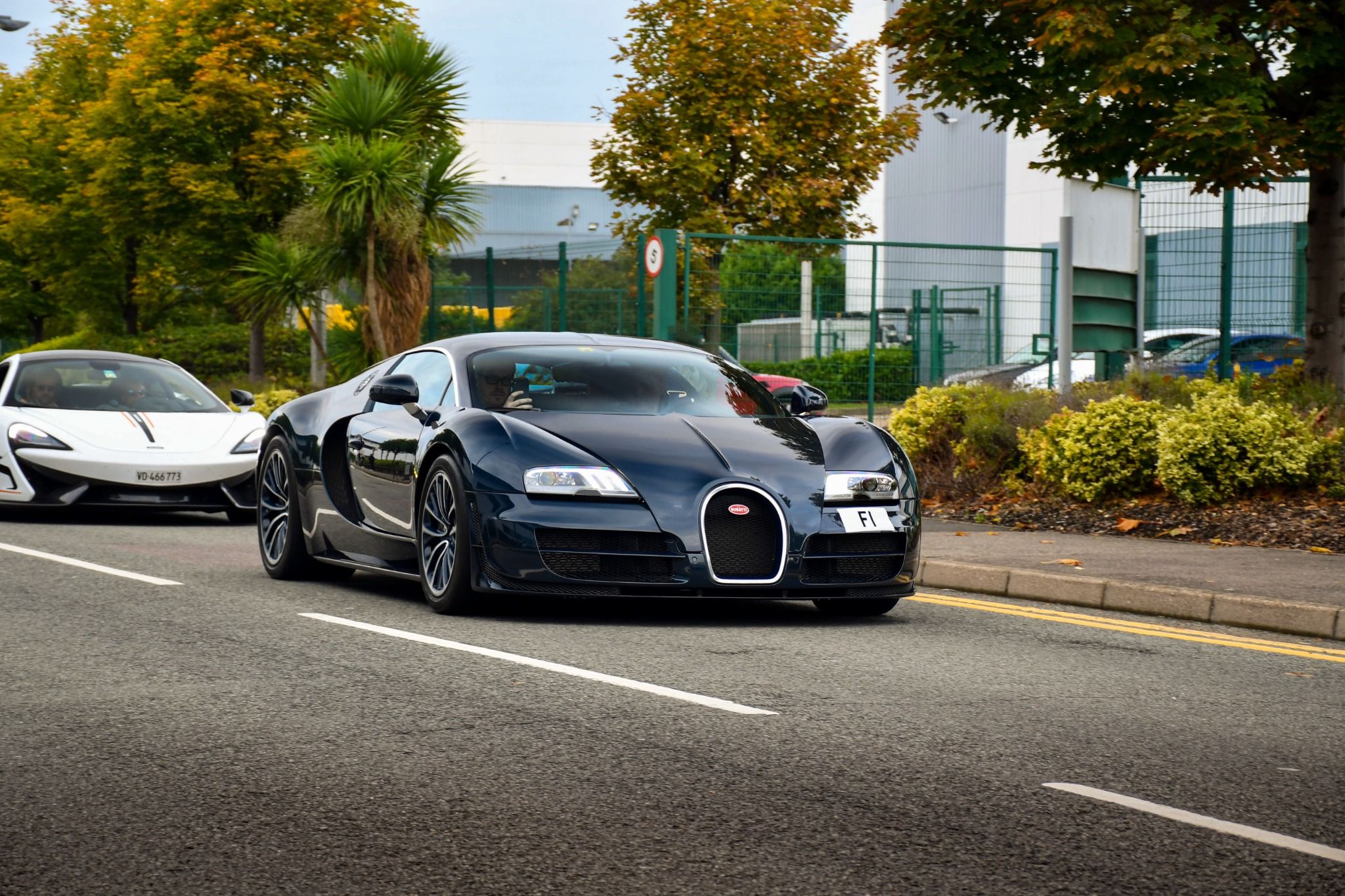 Black Bugatti driving down the road