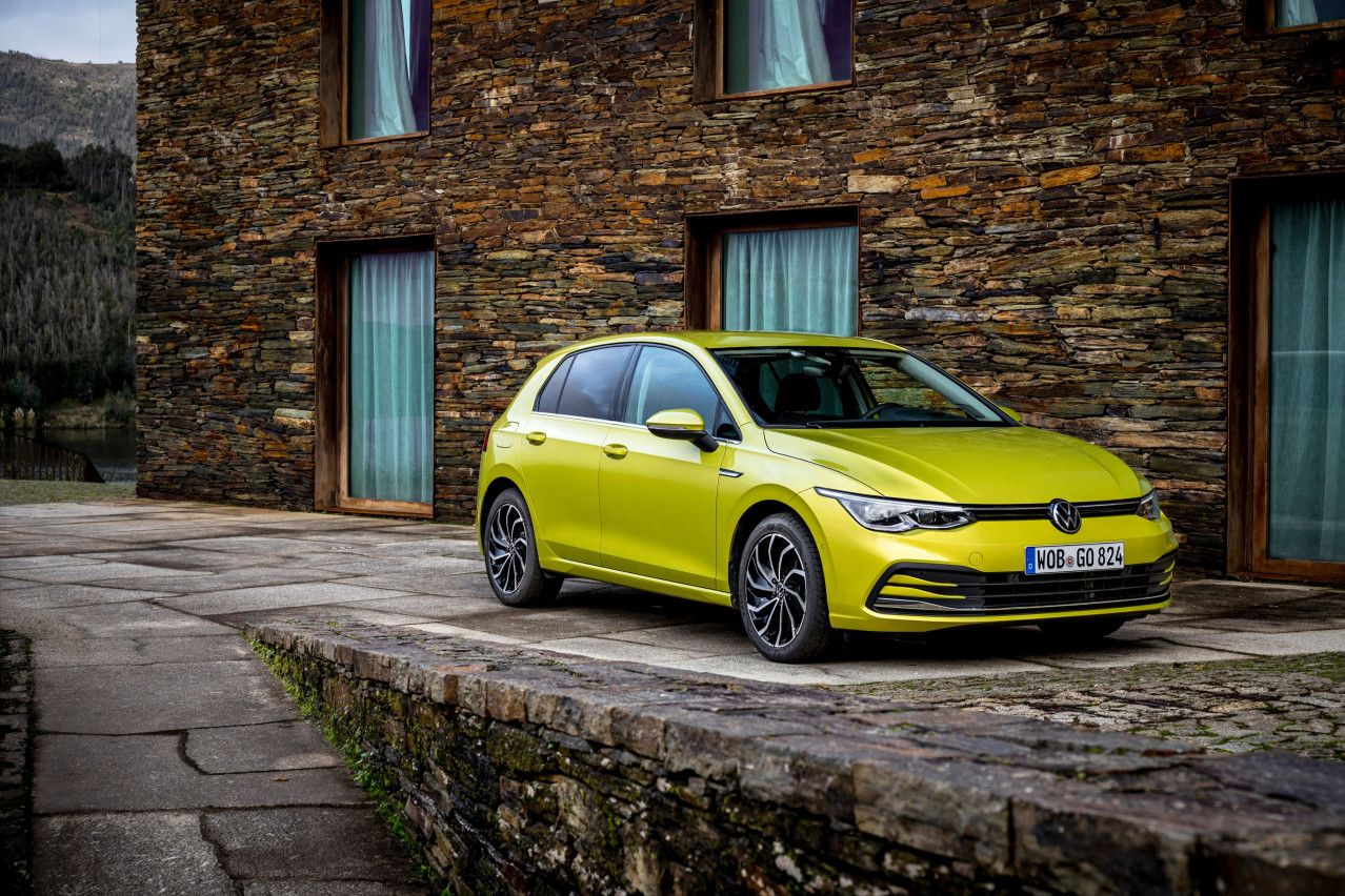 yellow volkswagen Golf parked infront of a brick building